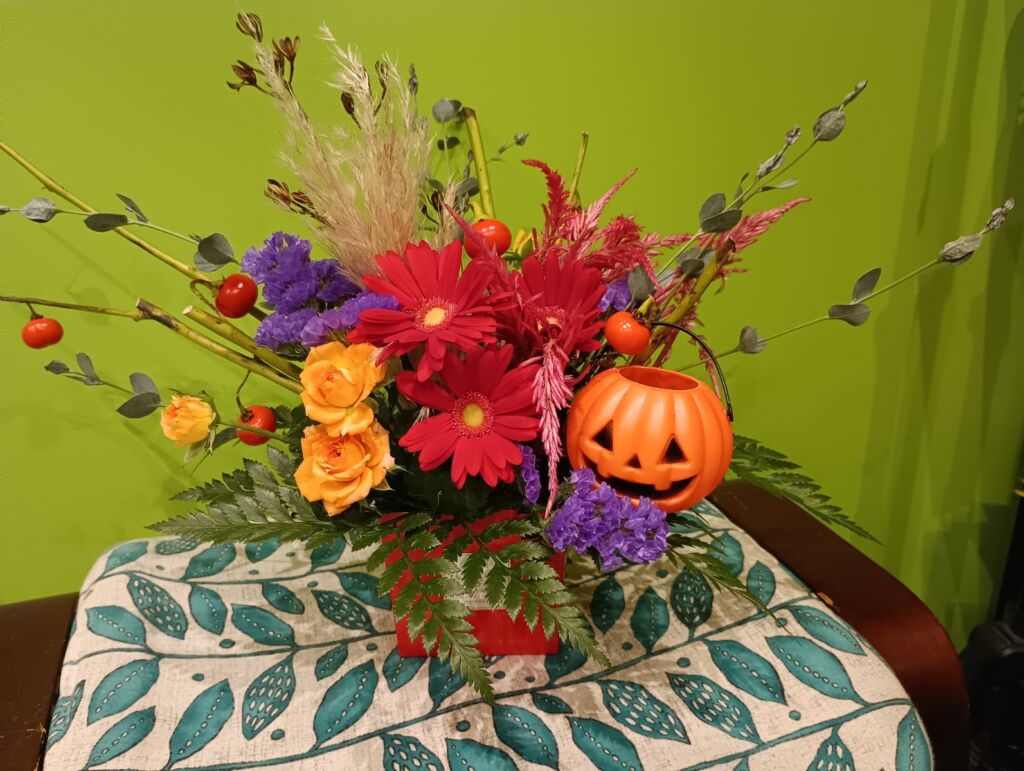 赤とオレンジの花で作るハロウィン仕様のフラワーアレンジメント。秋らしい華やかなデザイン。
